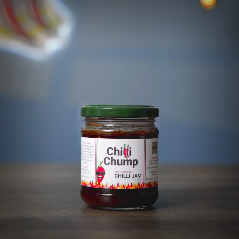 Image of the jar of Handcrafted Chilli Jam, showing the vibrant red preserve used as a sweet and spicy condiment for cheese and savoury food.