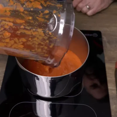 Pouring blended kebab shop chilli sauce into a pan from a blender
