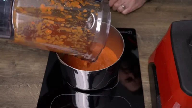 Pouring blended kebab shop chilli sauce into a pan from a blender