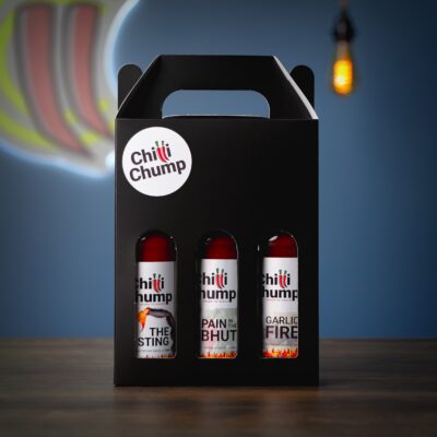 ChilliChump Super Hot Hot Sauce Gift Box in a black presentation box, front view showing The Sting, Pain in the Bhut and Garlic Fire bottles through the window cutouts.