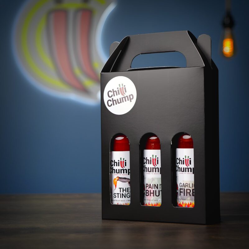 ChilliChump Super Hot Hot Sauce Gift Box in a black carry box with handle, angled view showing The Sting, Pain in the Bhut and Garlic Fire bottles inside.